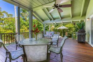 a porch with a table and chairs and a ceiling fan at Paradiso Hale in Princeville
