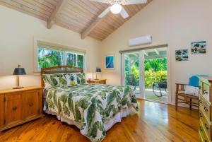 a bedroom with a bed and a wooden floor at Paradiso Hale in Princeville