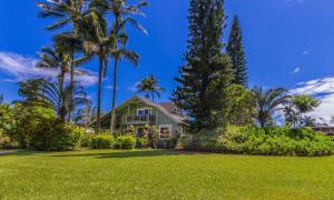 a house with palm trees and a yard at Paradiso Hale in Princeville