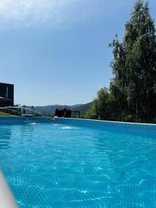 a large swimming pool with blue water at Memories Carpaty in Mizhhirʼʼya