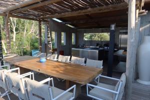 an outdoor dining area with a wooden table and chairs at Villa Paradisu in Monticello