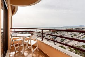 un balcone con tavolo e sedie e vista sull'oceano di GuestReady - Vibrant flat w/ balcony a Costa da Caparica