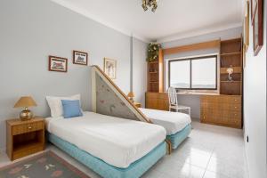 una camera da letto con due letti e una finestra di GuestReady - Vibrant flat w/ balcony a Costa da Caparica