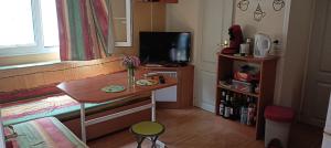 a small room with a table with a vase of flowers on it at Mobil home in Mallemort