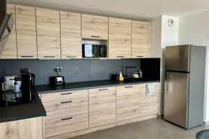 a kitchen with wooden cabinets and a stainless steel refrigerator at Air-conditioned Apartment with terrace in Illkirch-Graffenstaden