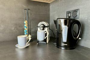 a coffee maker and two cups on a counter at Air-conditioned Apartment with terrace in Illkirch-Graffenstaden