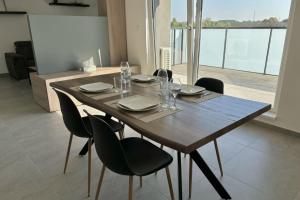 a wooden table with chairs and plates and wine glasses at Air-conditioned Apartment with terrace in Illkirch-Graffenstaden +12 photos