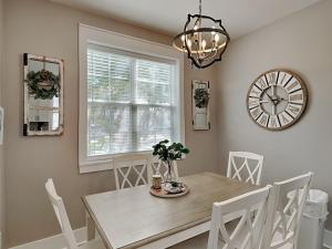 a dining room with a table and a clock on the wall at Bungalows at Seagrove #138 in Seagrove Beach