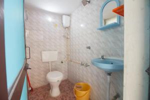 a small bathroom with a toilet and a sink at Sai Rooms in Puducherry