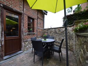 a table and chairs with an umbrella on a patio at Cozy Family Stay in Durbuy in Durbuy