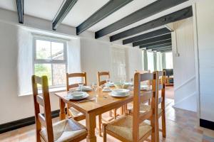 Un comedor con mesa y sillas de madera. en The School House, en Walton West
