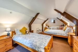Un dormitorio con dos camas en un ático. en Buckinghams Leary, en West Buckland