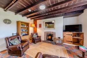 sala de estar con sillas de cuero y chimenea en Maenllwyd, en Llanrhystyd