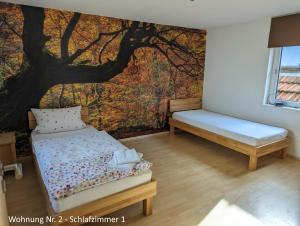 ein Schlafzimmer mit einem Baumbild an der Wand in der Unterkunft Ferienwohnungen Schallenberg Nr 2 in Groß-Umstadt