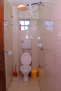 une salle de bain avec toilettes et douche dans l'établissement Smart 1BR Apartment in Meru Fast Wi-Fi Near Kinoru Stadium, à Gatunga