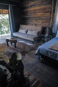 un soggiorno con un letto e un divano di Cabana Rústica a São Thomé das Letras