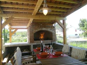 a patio with a table and a brick fireplace at Holiday Home Lorraina in Štivan