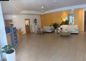 a large living room with couches and tables at Strandhotel Faak in Faak am See