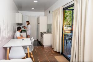 un homme et une femme debout dans une cuisine dans l'établissement EcoMódulos Termas Villa Elisa, à Villa Elisa