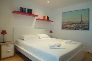 Un dormitorio con una cama blanca con dos toallas encima. en Appartement Harmonie - Welkeys, en Ciboure