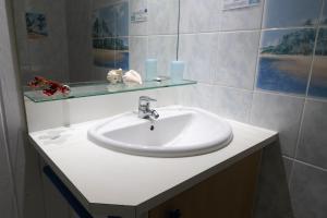 a bathroom with a white sink and a mirror at Gite le colibri Bungalow Azur avec réserve d'eau in Saint-François +16 photos