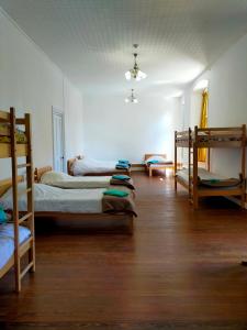 a room with three bunk beds and a living room with a couch at Chambre chez l'habitant in Saint-Geoire-en-Valdaine