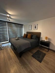 a bedroom with a large bed and a table at Céntrico y moderno in Concepción