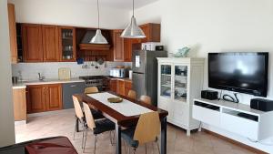 a kitchen with a dining table and a tv at Casa Il Volo in San Zeno di Montagna
