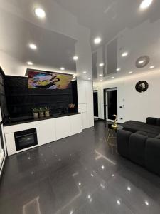 a living room with a couch and a flat screen tv at Jas Pipera Studio & Private Pool in Voluntari