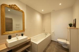 a bathroom with a sink and a tub and a toilet at Le 240, entre lac et montagnes in Les Rousses +26 photos