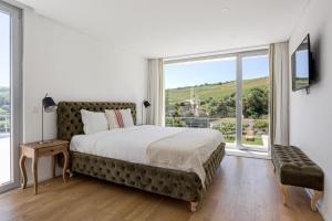 a bedroom with a large bed and a large window at GuestReady - Exquisite villa w/ Pool & Parking in Pancas