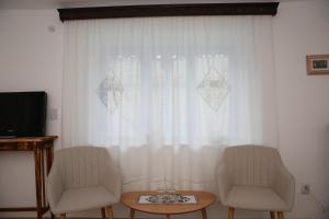 two chairs and a table in front of a window at Casa Ivana Jurilovca in Jurilovca
