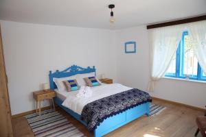a bedroom with a blue bed with a cat on it at Casa Ivana Jurilovca in Jurilovca