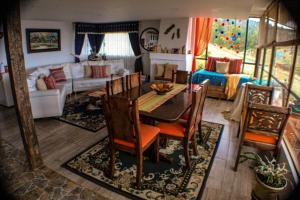 a living room with a table and chairs and a couch at Balcones del Lago de Tota in Sogamoso