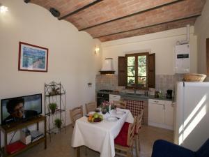 a kitchen and dining room with a table and a refrigerator at Farmhouse in Tuscany near Siena & Hot Springs in Castelnuovo Berardenga