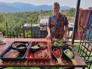 a woman standing in front of a table of food at Villa la Cerisaie in Céret +4 photos