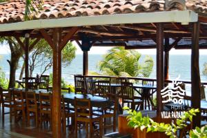a restaurant with a table and chairs and the ocean at Hotel Villa Paraiso in Santo Domingo