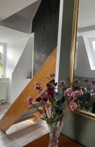 a vase with flowers on a table next to a staircase at Ferienwohnung Maria mit Elbblick in Coswig