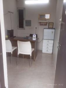 韦洛尔Golden stayz Inn的办公室,配有桌子和两把椅子,还有柜台