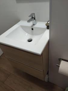 lavabo blanco en un baño con suelo de madera en Rincón del Mar, en Rincón de la Victoria 4 fotos más