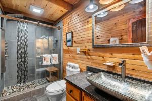 a bathroom with a sink and a shower and a toilet at Moonlit Mountain Lodge by American Patriot Getaways in McCookville +50 photos