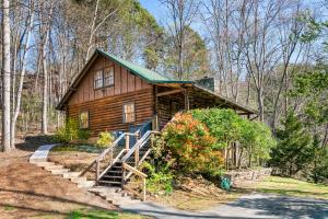 a log cabin in the woods with stairs leading to it at Moonlit Mountain Lodge by American Patriot Getaways in McCookville