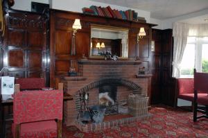 a living room with a brick fireplace with a mirror at The Down Inn in Bridgnorth