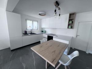 a kitchen with a wooden table and white cabinets at Casa Oasi Brusino in Brusino Arsizio