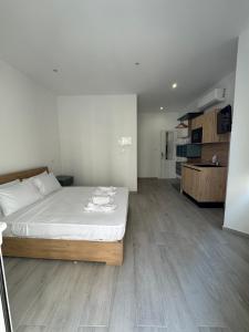 a bedroom with a bed with white sheets and wooden floors at The Collective Guesthouse in Sliema