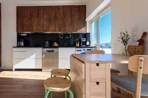 a kitchen with white cabinets and a table and chairs at Almada Comfort in Almada