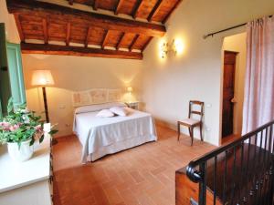 a bedroom with a bed and a chair in a room at Cottage in Val di Chiana in Castiglion Fiorentino