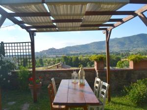 a wooden table and chairs under a pergola at Cottage in Val di Chiana in Castiglion Fiorentino