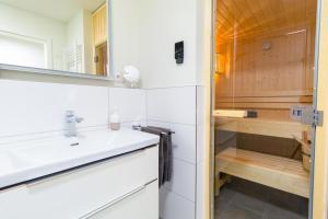 a bathroom with a sink and a shower at Ferienwohnung Meerglück mit Balkon und Sauna - 300 m vom Strand entfernt in Kellenhusen
