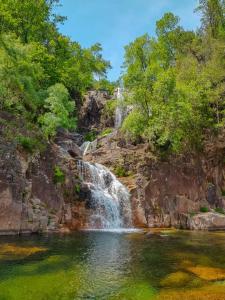 a waterfall in the middle of a pool of water at M&L Gerês in Salamonde